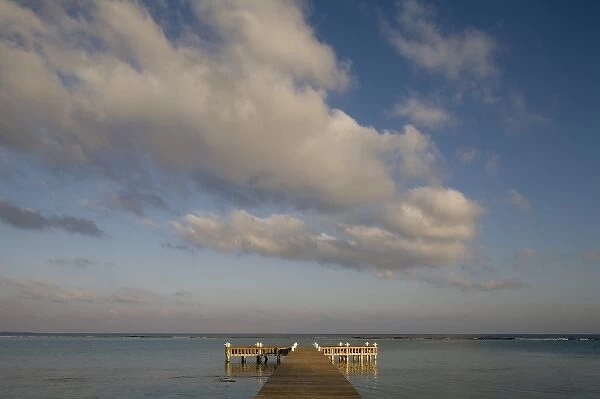Cayman Islands, Little Cayman Island, Setting sun lights wooden boat pier in Caribbean