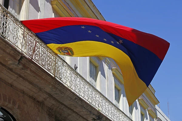 Central America, Cuba, Havana. Venezuela flag flies from balcony in Havana, Cuba