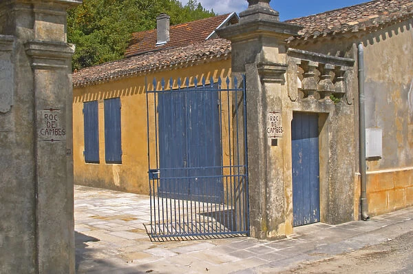 The Chateau Roc de Cambes with stone wall iron gate and stone gate posts with the name carved