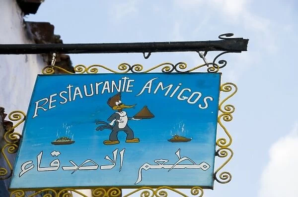 Chefchaouen Morocco restaurant Amigos sign with woodpecker holding a tagine