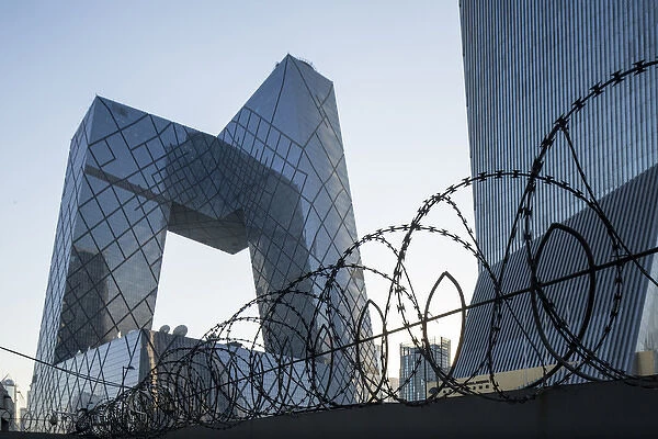 China, Beijing, Barbed wire surrounds perimeter of gleaming steel and glass CCTV