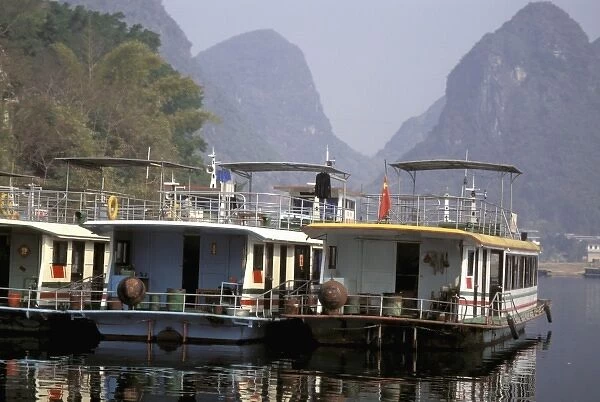 China, Guangxi province. Colorful river tour boats moored along the shore- Li river