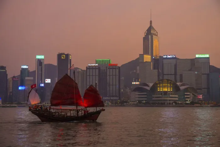 Framed Print : China, Hong Kong. Downtown buildings and boat in harbor at sunset