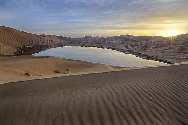 China, Inner Mongolia, Badan Jilin Desert. Sunrise on desert and lake. Credit as