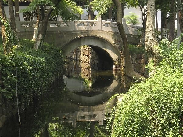 China, Nantong, an arched bridge forms a perfect reflection at the base of Wolf Hill