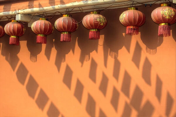 Chinese Lanterns and shadows playing on colorful wall in Kunming Ethnic Minorities Village Park