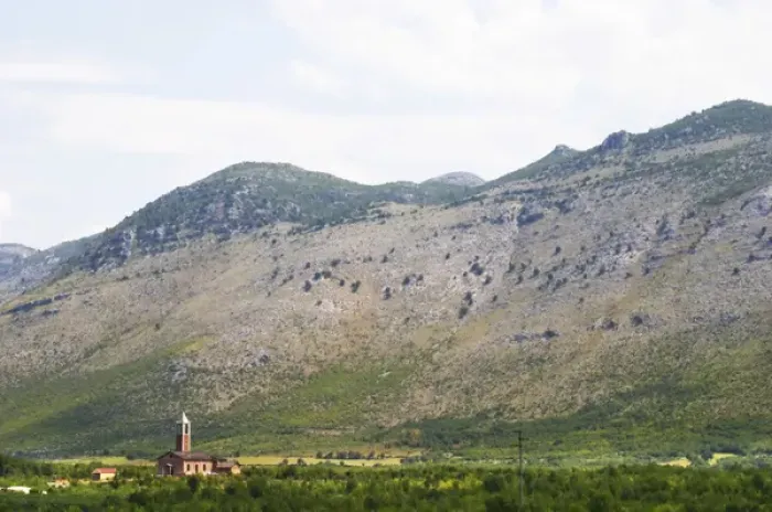 Framed Print : A church on the plain dominated by the Kastrat Shkrel mountains near Koplik Framed Print : A church on the plain dominated by the Kastrat Shkrel mountains near Koplik