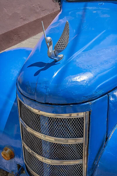 Detail of classic blue American car with chrome swan hood ornament in Trinidad, Cuba