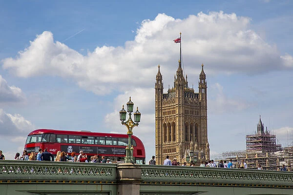 Classic double decker tour bus in London, England crossing the bridge River Thames with