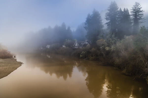 The clearing fog from the Russian River with the houses along the riverbank early morning