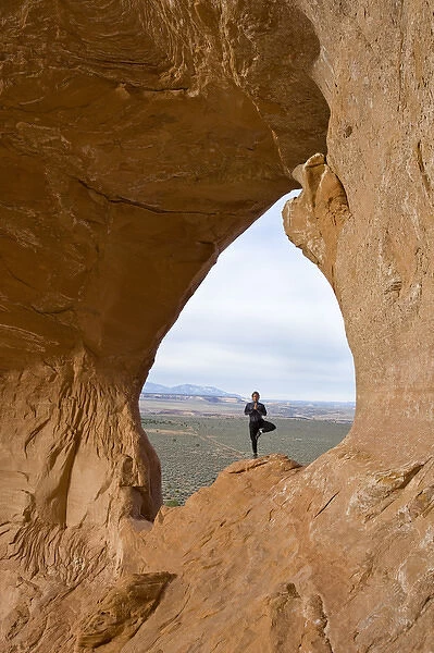 Climbing guide with Moab Desert Adventures, does yoga on Looking Glass Rock, near Moab