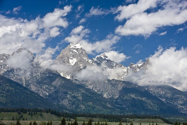 Clouds move over Grand Teton peak on a sunny day - Grand Teton National Park, Wyoming