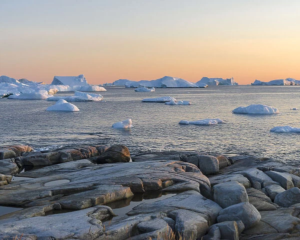 Coastal landscape with Icebergs. Inuit village Oqaatsut (once called Rodebay) located in Disko Bay