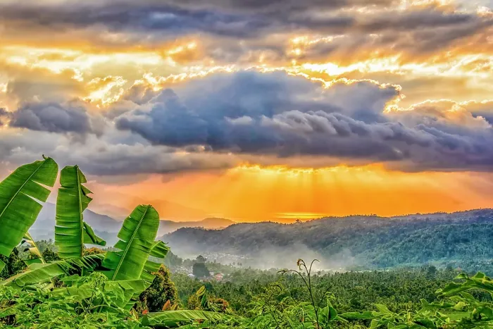 Framed Print : Coastal valley, Bali, Indonesia. Landscape view of sun breaking through clouds over a lush valley at sunset