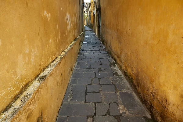 Cobblestones and yellow walls in alleyway, Hoi An (UNESCO World Heritage Site), Vietnam