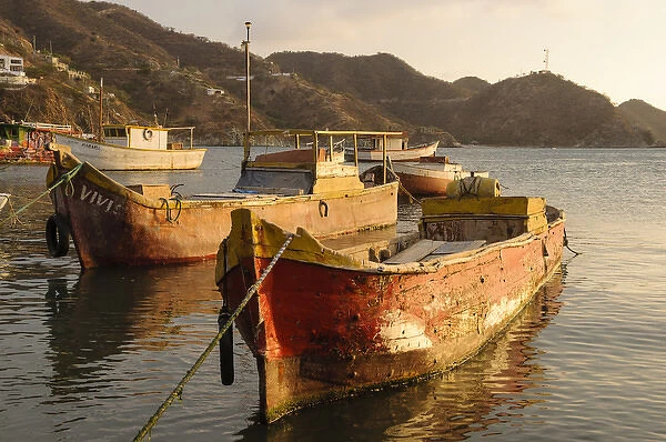 Colombia, Taganga. Fishing boats in harbor at sunset