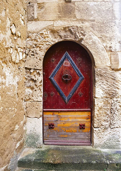 Colorful door in the stone wall of a chateau in France