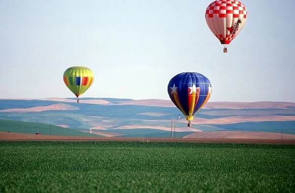 Colorful hot air balloons float over wheat fields in Walla Walla, Washington