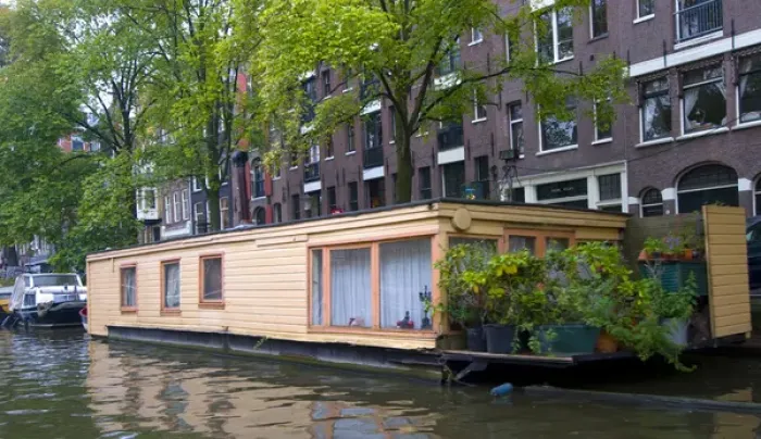 Framed Print : A colorful peach houseboat on a tree lined canal