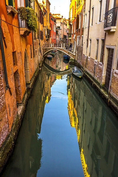 Colorful small canal and bridge creates beautiful reflection in Venice, Italy