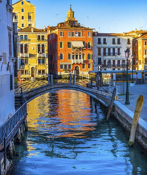 Colorful small canal and bridge Grand Canal creating beautiful reflection in Venice