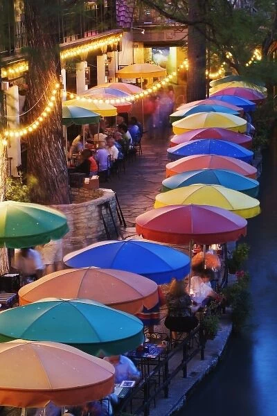 Colorful umbrellas of outdoor cafe along famous River Walk and San Antonio River