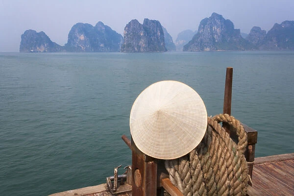 Conical hat on junk boat and karst islands in Halong Bay, UNESCO World Heritage site