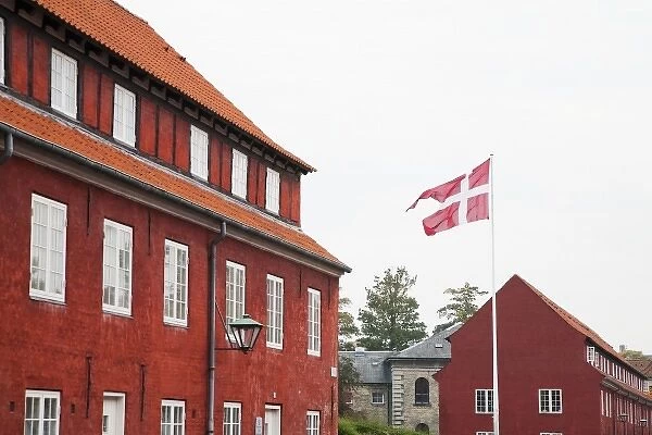 Copenhagen, Denmark - A Danish flag is flying in front of red military barracks