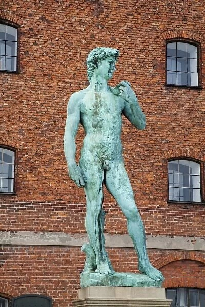 Copenhagen, Denmark - Low angle view of a sculpture of David. A brick building is