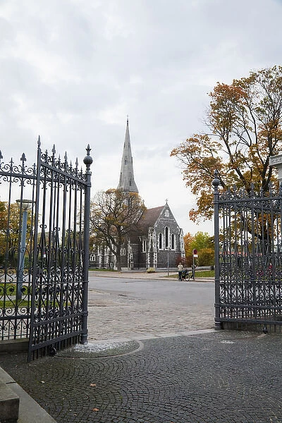 Copenhagen, Denmark - Open wrought iron gates leading to the cobblestone courtyard of a church