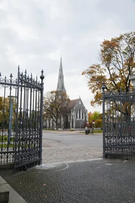Framed Print : Copenhagen, Denmark - Open wrought iron gates leading to the cobblestone courtyard of a church