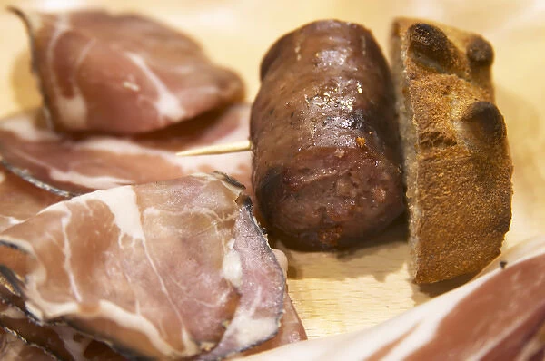 Corsica style charcuteries, smoked and dried ham, sausages on a wooden cutting board