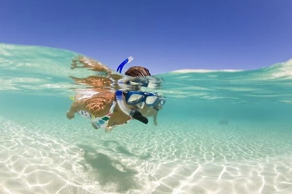 couple (age 23 and 24) enjoying snorkeling the clear tropical waters of a remote island