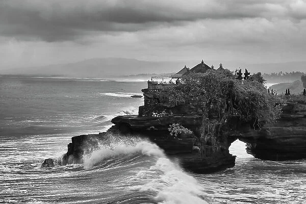 Crashing waves on the lava rock shoreline of Tanah Lot Temple, Bali, Indonesia