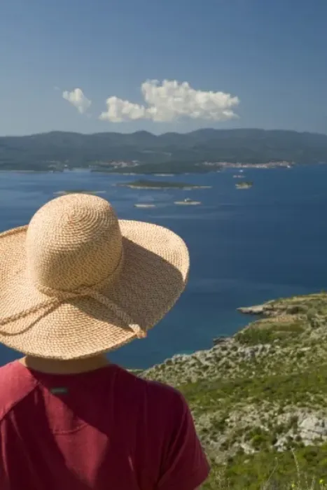 Framed Print : Croatia, Dalmatia, Female tourist in straw hat gazes at lush fields and town of Orebic