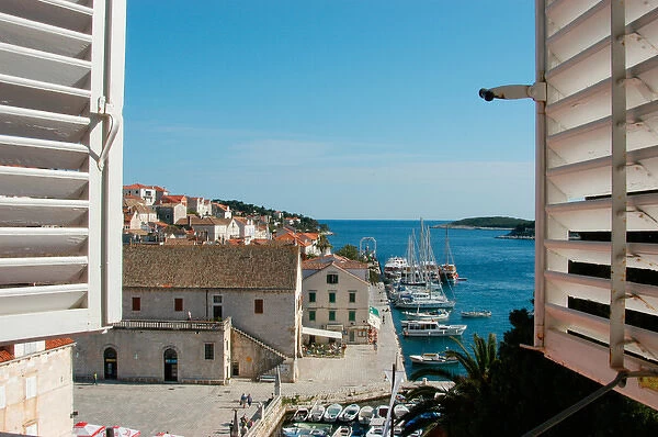 Croatia, Dalmatian Coast, Hvar, view of the harbor, boats and Riva seen thru shuttered