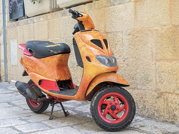 Croatia, Hvar. Bright orange vespa bike in the town of Hvar. (Editorial Use Only)