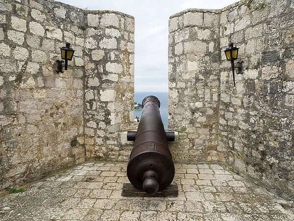 Croatia, Hvar. Old cannon overlooking the island town and coastline from Hvar Fortica or Spanjola Fortress