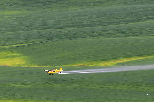 Crop duster applying chemicals on wheat fields from Steptoe Butte near Colfax, Washington State, USA