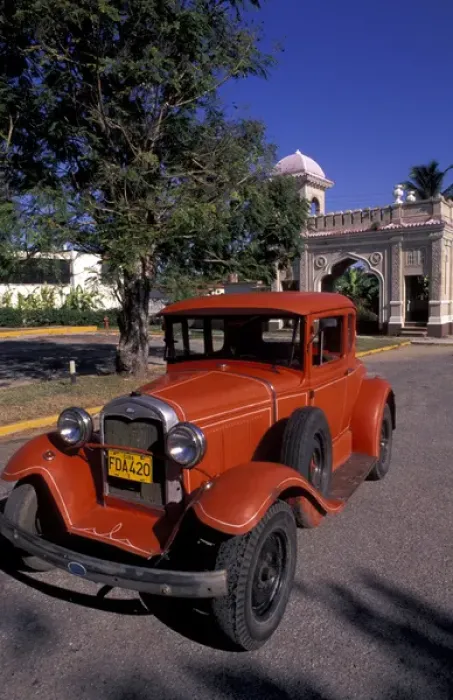 Framed Print : Cuba, Cien Fuergos, Old Model A Ford and colorful architecture behind