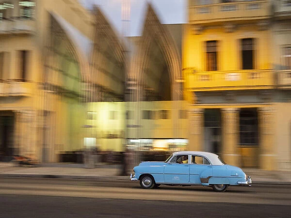 Cuba, Havana, classic car in motion at dusk on Malecon