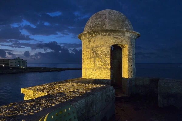 Cuba, Havana. Golden light illumines stone turret of old fort