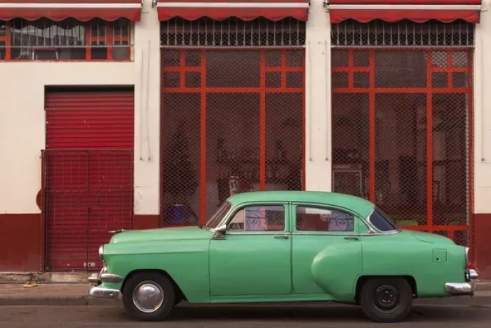 Framed Print : Cuba, Havana. Green car, red building on the streets
