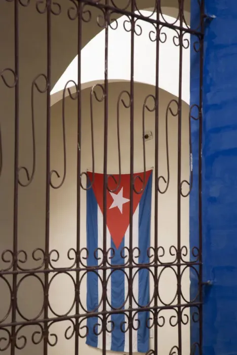Framed Print : Cuba, Vinales, Cuban flag in courtyard and wrought iron gate