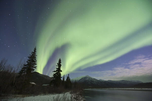 Curtains of green aurora borealis dance in the sky over the Middle Fork of the Koyukuk