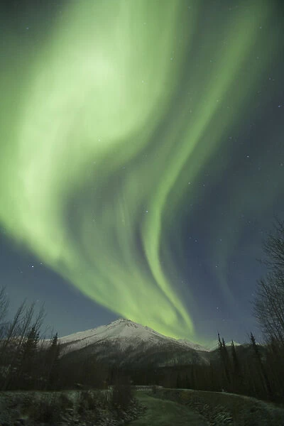 Curtains of green aurora borealis dance in the sky over unnamed peaks in the Central