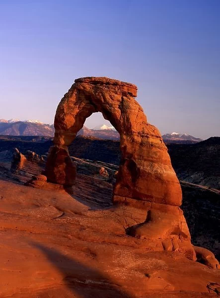 Delicate Arch at Sunset with snow covered La Sal mountains in the background