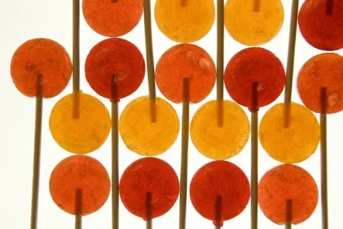 Framed Print : Design with red and orange lollipop candy on sticks