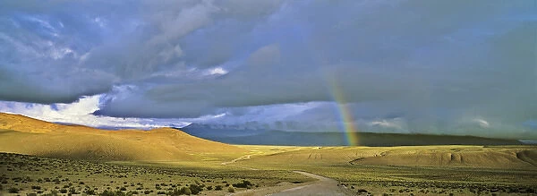 Dirt Road with rainbow, Altiplano, Chile, near Salar de Surire... America, South America
