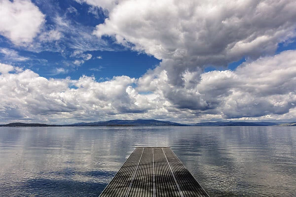 Dock reaches out into Skidoo Bay in Flathead Lake near Polson, Montana, USA